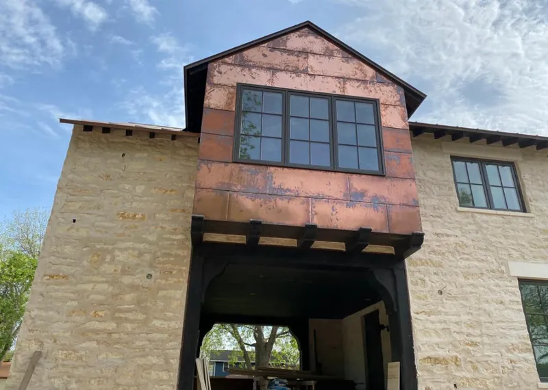Copper metal panel facade on a stone building for Skylight Installation in Shady Hollow